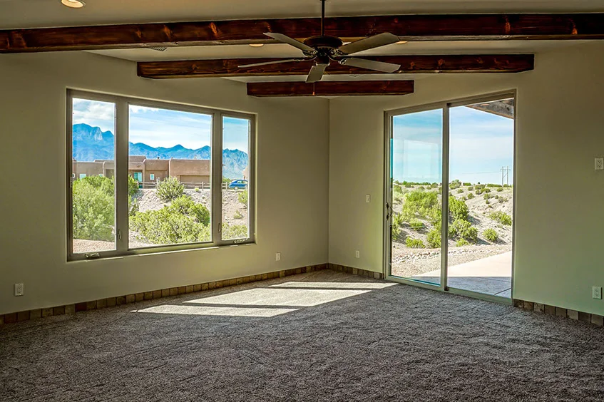 A bedroom in The Mesa framing mountain views through a window and patio door