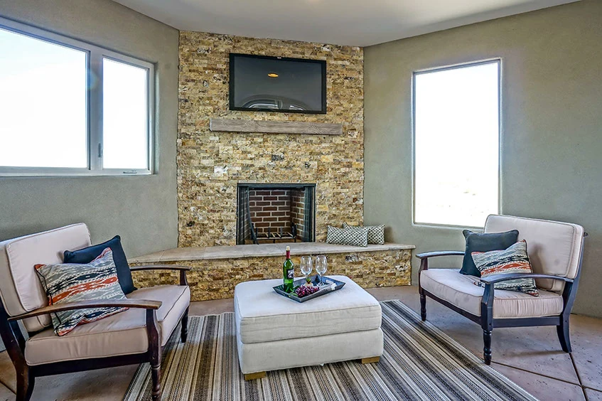 A quiet Cielo sitting room with stone fireplace and framed windows